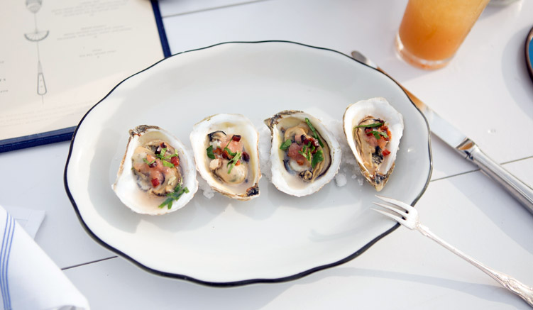 Baked oysters with shallot marmalade, slab bacon, lemon and parsley